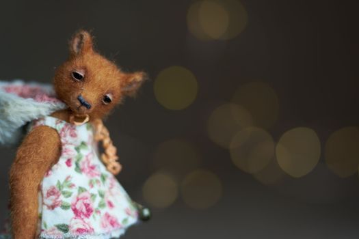 Cute teddy bear isolated on light background. Holiday glowing backdrop. Defocused background with blinking light. Blurred Bokeh. copy space. High quality photo