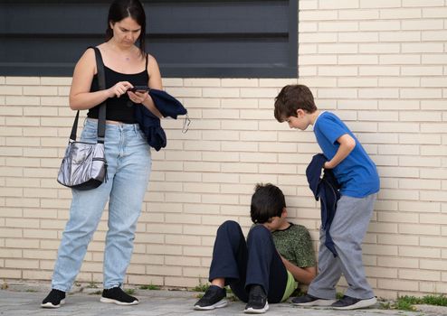 Family staying in a street , addicted and obsessed with modern gadgets. Stock footage. Kids using mobile phone while mother is overusing her smartphone, avoiding ignoring each other