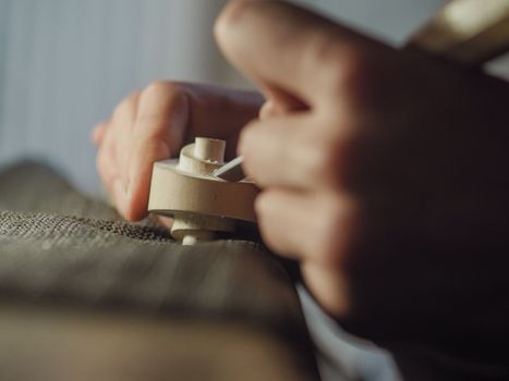 violinmaker working on a handmade contemporary stringed instrument scroll