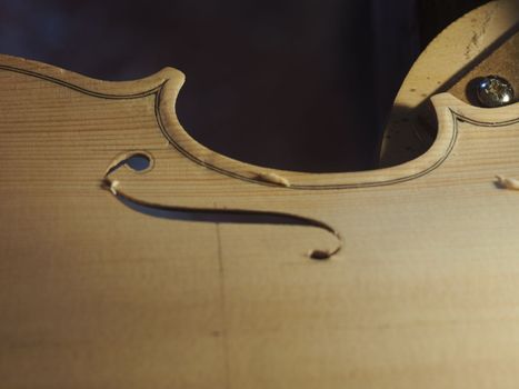 violinmaker cutting and sawing golden period cremonese violin model fholes with a blade with precision