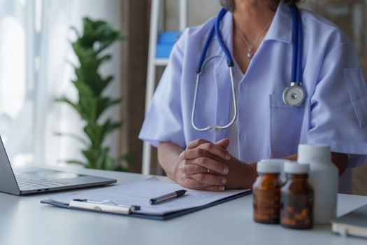 Doctor having conversation with patient while discussing explaining symptom and hold hand for encourage.