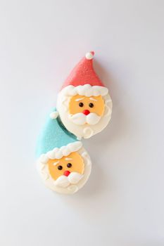 Two sweet dessert in the form of a Santa Claus head with a red riding hood, isolated, on a white background. View from above. Vertical