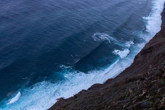 ocean surf waves at sunset view from above. High quality photo