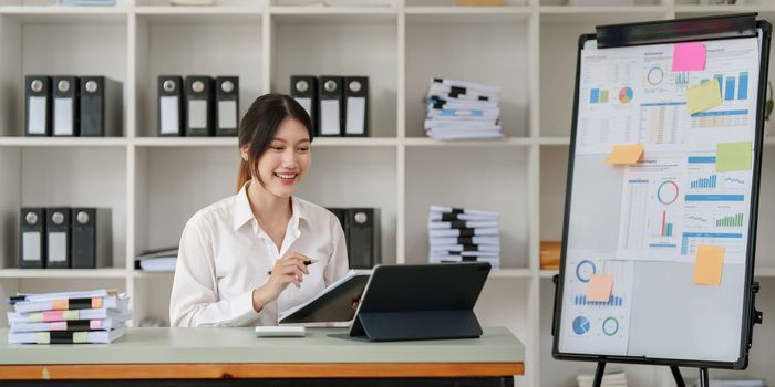 Pleasant positive business woman using digital tablet at home office.