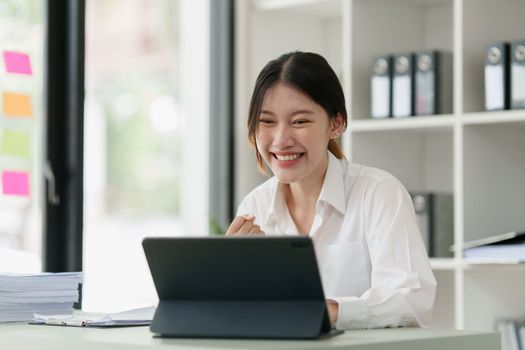 Pleasant positive business woman using digital tablet at home office.