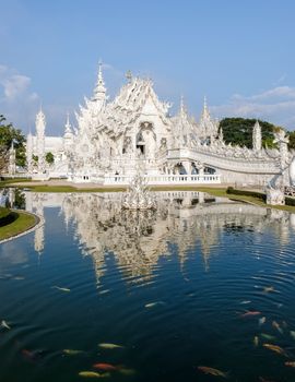 White temple Chiang Rai Thailand, Wat Rong Khun, aka The White Temple, in Chiang Rai, Thailand with a blue sky and reflection in the lake