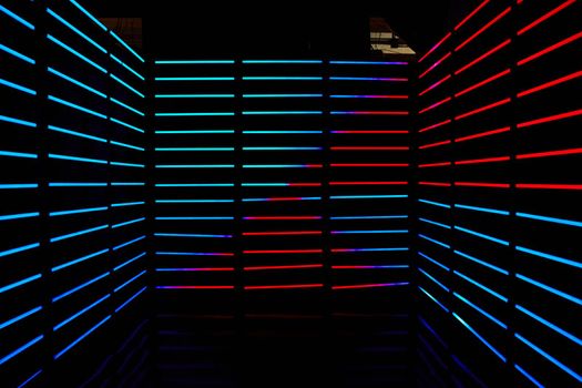 Image of Empty dark room lined with red and blue LED horizontal poles of light