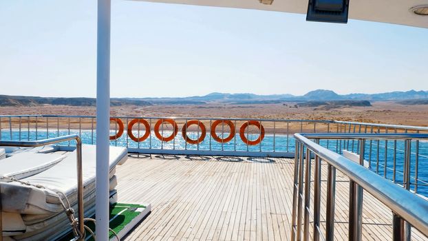 summer, sea, flight of a video camera along the deck of the ferry, ship, on board hangs many orange lifebuoys. High quality photo