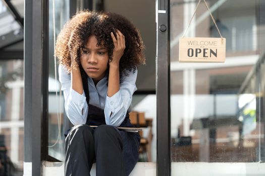 black woman waiter of street cafe is waiting for clients, customersm she is bored, no people in their cafe. small business owner