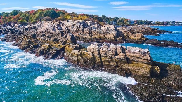 Image of Waves crash into patch of rocky coastline in Maine
