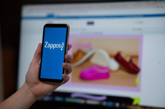 December 3, 2022 Almaty Kazakhstan: Faceless woman holding smartphone with Zappos logo on monitor background