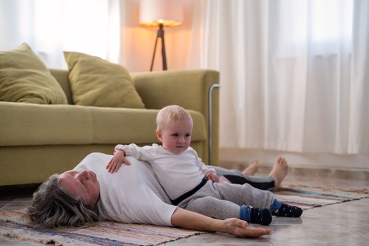 senior woman doing warmup workout at home. Fitness woman doing stretch exercise stretching her body. Elderly woman living an active lifestyle. 