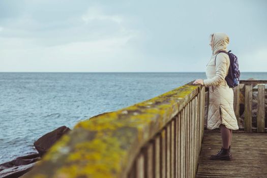 Lonely woman standing on a pier in Denmark.