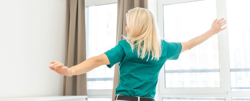 Women enjoy the coolness while standing in front of the air conditioner.