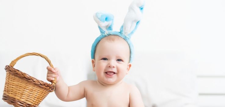 happy baby child with Easter bunny ears and colorful eggs.