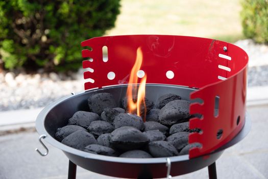 a man lights a fire with a lighter special charcoals for a barbecue a barbecue house on the terrace prepares a place for a barbecue. High quality photo