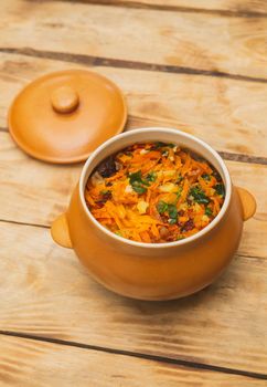 Potatoes baked in a pot with meat and vegetables.