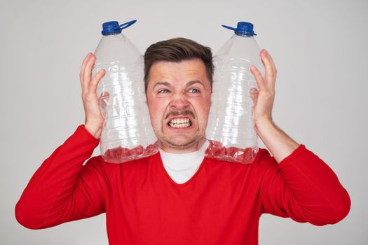 Caucasian man holding empty plastic bottles for water. Pure water crisis concept.