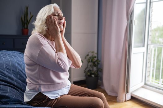 Middle age woman touching mouth with hand with painful expression because of toothache or dental illness on teeth. 