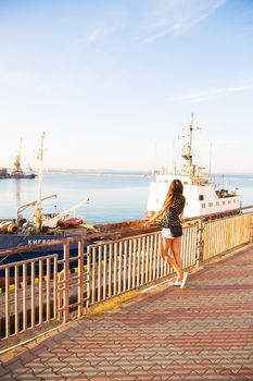 Girl stands with his back to the port of Odessa