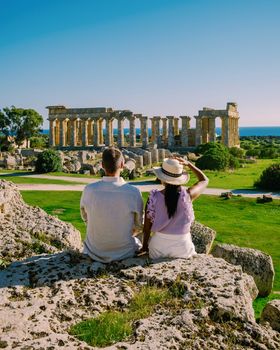 A couple visit Greek temples at Selinunte during vacation, View on sea and ruins of greek columns in Selinunte Archaeological Park Sicily Italy