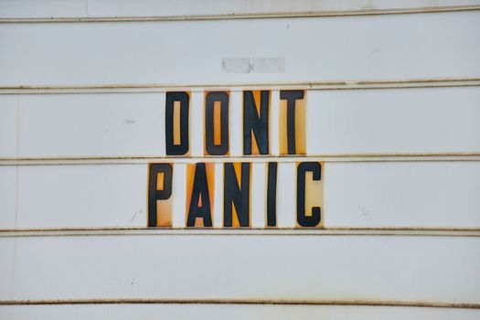 Image of Detail of road sign all white with black capital letters DONT PANIC from Hitchhikers Guide to the Galaxy