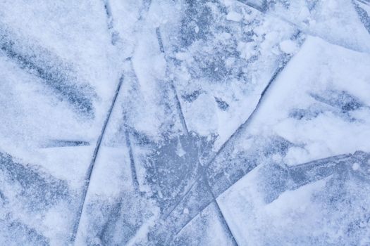 Empty ice rink with skate marks after the session outdoor. skating ice rink texture covered with snow in daylight. Close up of blue ice rink floor, copy space