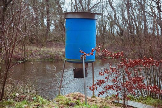 Automatic deer feeder in the autumn forest in Denmark.