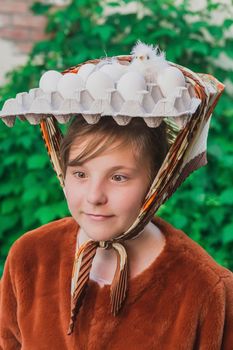 Teenage girl with eggs and chick on her head.