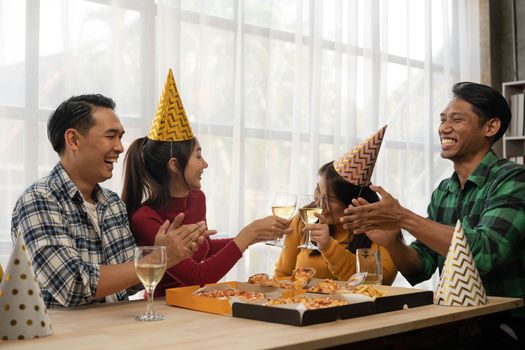 Group of asian friends eating pizza during party at home. Happy asian people having fun together, eating pizza food and beer together with happiness and fun