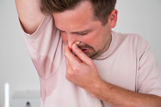 Man with hyperhidrosis sweating very badly under armpit. Hot weather.