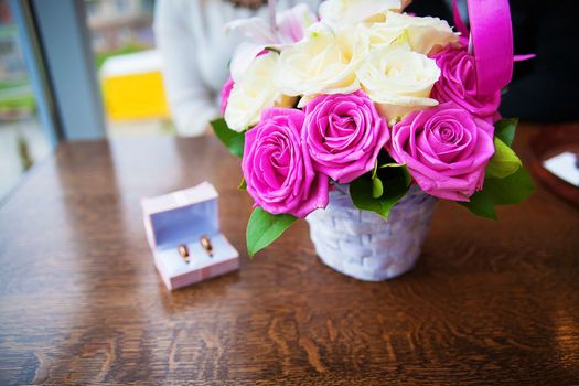 bouquet of beautiful and colorful flowers and wedding rings in a box.