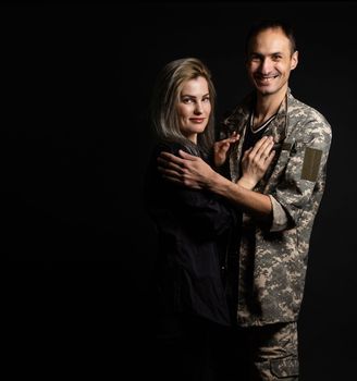 military man and his wife on a black background.