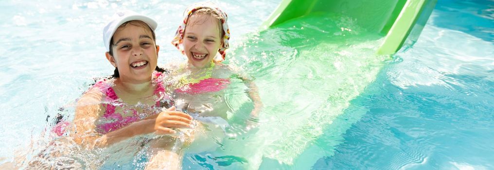 Happy children in the swimming pool. Funny kids playing outdoors. Summer vacation concept