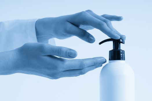 Woman hands pushing pump plastic soap bottle