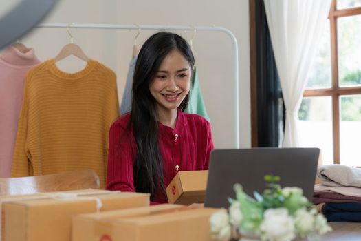 Startup small business entrepreneur of freelance Asian woman using a laptop with box Cheerful success online marketing packaging box and delivery SME idea concept.