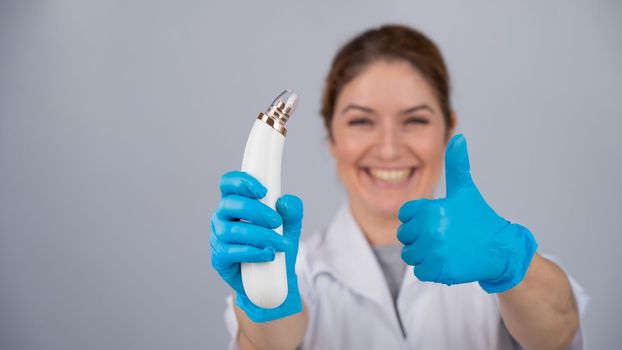 Doctor dermatologist recommends vacuum skin cleaner at home and shows thumbs up