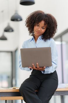 Portrait young african american businesswoman looking at laptop. Woman reading news, report or email. Online problem, finance mistake, troubleshooting.