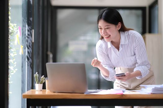 Asian business are excited about celebrating business success with inspiration from their excellent financial results that are happy working in a modern office