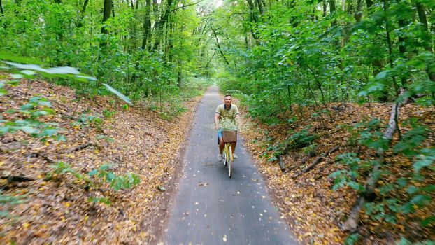 a man with a child riding a bicycle in the forest, in the summer, the child is sitting in a special chair. High quality photo