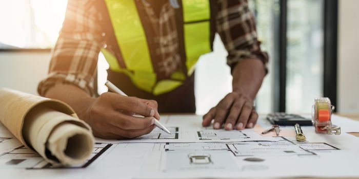 Professional architect designer structural engineer team colleagues discussing building plan design project.