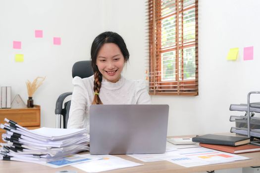 Cheerful lady working on laptop in home and use a computer laptop and thinking idea for her business..