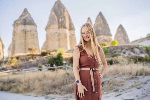 Woman tourist on background of Unique geological formations in Love Valley in Cappadocia, popular travel destination in Turkey.