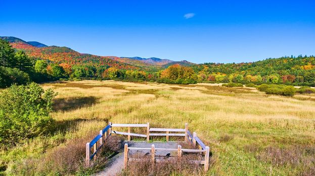 Image of Viewing spot for tourists overlooks beautiful field and colorful fall mountains