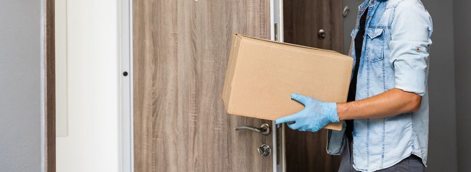 Home delivery shopping box man wearing gloves and protective mask delivering packages at door.