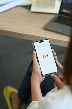 Chiang Mai, Thailand - Oct 08,2022: Woman iPhone 14 Pro Max with Gmail app on screen. Gmail is a free email service from Google.