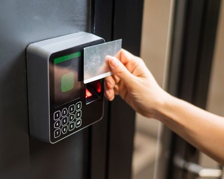 A woman opens the door with a plastic card. Modern keyless entry lock