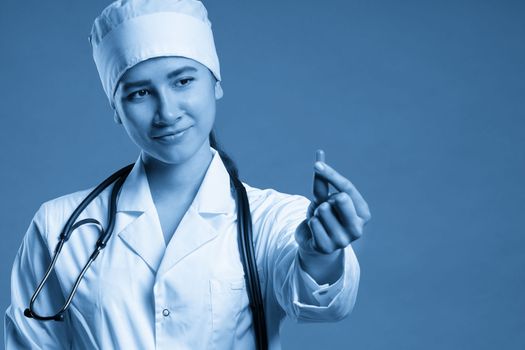 female pharmacist holding a pill, health care and prevention concept, hand close up
