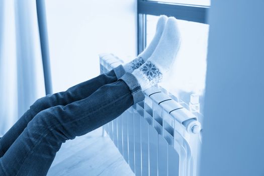 Woman warming up with feet on heater