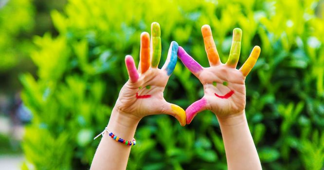 Children's hands in the colors of summer. Selective focus.arts